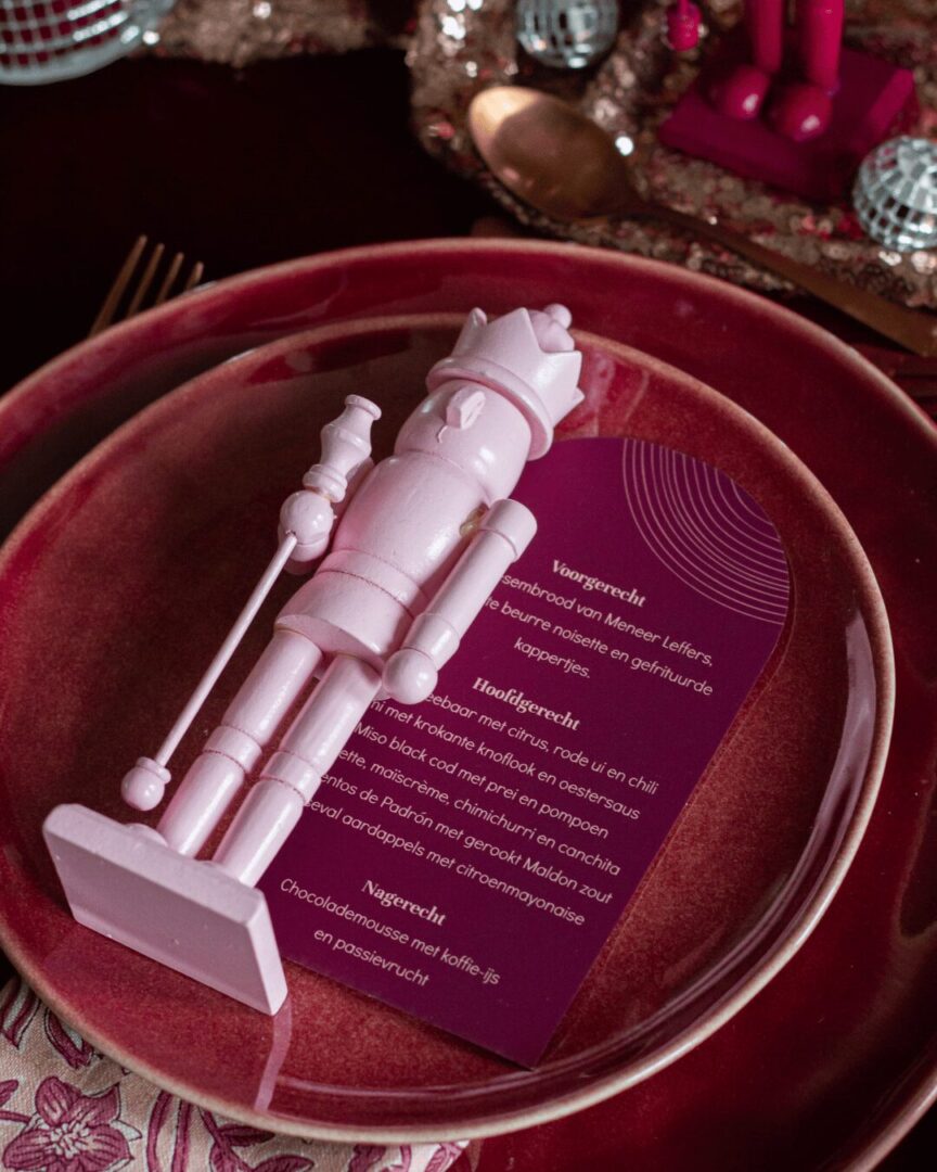 notenkraker roze op dinerbord met menukaart